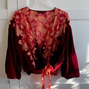Luscious red velvet wrap blouse with sheer red paneling.
